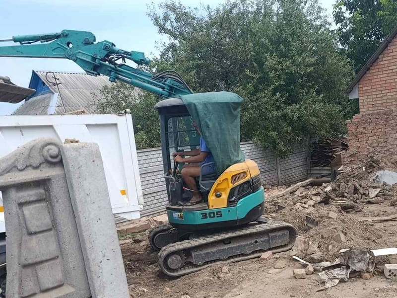 Мініекскаватор Kubota з нашим водієм розбирає старий будинок