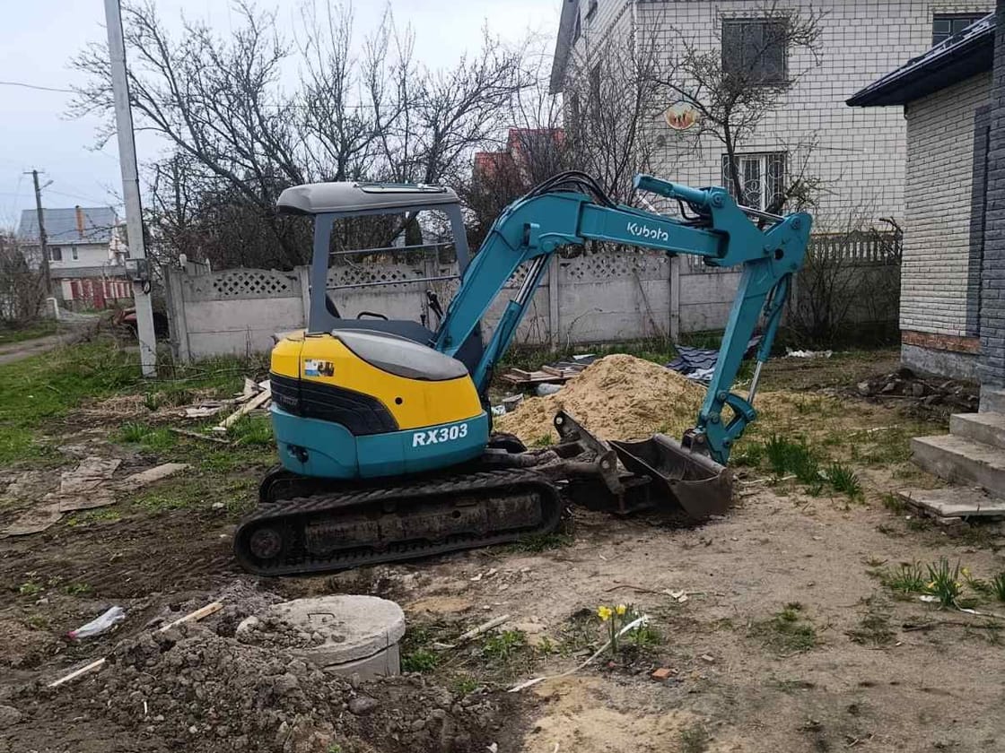 Мініекскаватор Kubota копає у дворі приватного будинку у Вінниці